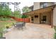 Relaxing patio with metal table and chairs, TV, complemented by a privacy fence and natural landscaping at 166 Nobility Ln, Mcdonough, GA 30252