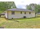 The back of the one-story home features brick and siding and the backyard has grass at 7279 Mayfair Cir, Jonesboro, GA 30236