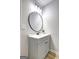 Bathroom vanity features a round mirror and modern lighting fixture at 7279 Mayfair Cir, Jonesboro, GA 30236