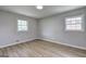 Bright bedroom featuring wood floors, two windows, and neutral paint at 7279 Mayfair Cir, Jonesboro, GA 30236