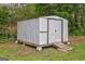 Outdoor shed with wooden ramp for easy access and ample storage space on a well-maintained lawn at 7279 Mayfair Cir, Jonesboro, GA 30236