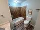 Cozy bathroom featuring a tub with tiled walls, toilet, and wood-look flooring at 2691 Old South Dr, Jonesboro, GA 30236