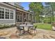 Outdoor patio with stone flooring, a dining table, and a view of the landscaped backyard at 400 Conservatory Pt, Fayetteville, GA 30215