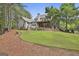 Expansive backyard featuring a covered porch, stone patio, and lush green lawn at 400 Conservatory Pt, Fayetteville, GA 30215