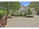 Beautifully landscaped home exterior with stone accents, a spacious driveway and three car garage at 400 Conservatory Pt, Fayetteville, GA 30215