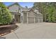 Beautiful home exterior with a three-car garage, gray siding, and manicured landscaping at 400 Conservatory Pt, Fayetteville, GA 30215