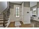 Bright foyer featuring hardwood floors, shiplap walls, and a staircase with iron spindles at 400 Conservatory Pt, Fayetteville, GA 30215