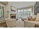 Cozy living room features a stone fireplace, large windows, and comfortable seating at 400 Conservatory Pt, Fayetteville, GA 30215