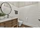 Stylish powder room featuring wood vanity, shiplap walls, and a round mirror at 400 Conservatory Pt, Fayetteville, GA 30215