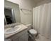 A well lit bathroom with a single sink, white cabinets and shower with curtain at 142 Hampton Cir, Mcdonough, GA 30253