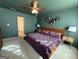 This bedroom boasts a ceiling fan, a purple comforter, and unique hexagonal wall decor at 142 Hampton Cir, Mcdonough, GA 30253