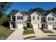 Charming townhouse featuring a brick facade, attached garage, and well-manicured front lawn at 142 Hampton Cir, Mcdonough, GA 30253