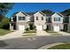 View of the townhouses featuring a brick facade, attached garage, and well-manicured front lawn at 142 Hampton Cir, Mcdonough, GA 30253