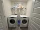 Bright laundry room with modern washer and dryer, organized shelf, and ample space at 142 Hampton Cir, Mcdonough, GA 30253