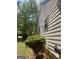 Side view of the home showing the siding, landscaping, and yard at 1047 Plantation Nw Way, Kennesaw, GA 30144