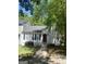 Charming home with a red front door, white siding and manicured front yard with mature landscaping at 1047 Plantation Nw Way, Kennesaw, GA 30144