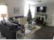 Inviting living room with fireplace, gray sofa, Christmas tree, and ample natural light at 1047 Plantation Nw Way, Kennesaw, GA 30144