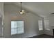 Bright living room featuring vaulted ceilings, a ceiling fan, and large windows for ample natural light at 1047 Plantation Nw Way, Kennesaw, GA 30144