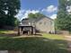 Large backyard featuring a gazebo covered hot tub, wooden deck and lush green grass at 30 Wellington Trl, Covington, GA 30016