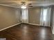 Bright bedroom featuring dark hardwood floors, neutral walls, ceiling fan and natural light at 30 Wellington Trl, Covington, GA 30016