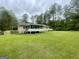 Well-maintained backyard showcasing a screened porch, lush greenery and a manicured lawn at 625 Locust Rd, Locust Grove, GA 30248