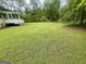 Spacious backyard with green grass and trees in the background at 625 Locust Rd, Locust Grove, GA 30248