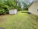 Spacious backyard featuring a storage shed, lush lawn, and a chain link fence, offering ample outdoor space at 625 Locust Rd, Locust Grove, GA 30248