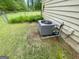 Backyard featuring lush green grass and the home's AC unit, perfect for outdoor enjoyment at 625 Locust Rd, Locust Grove, GA 30248