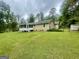 Expansive backyard with a screened-in porch, shed, and lush green lawn, perfect for outdoor activities at 625 Locust Rd, Locust Grove, GA 30248