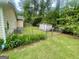 Fenced backyard featuring lush green grass, a storage shed, and mature trees, perfect for outdoor enjoyment at 625 Locust Rd, Locust Grove, GA 30248