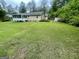Fenced backyard featuring lush green grass, a storage shed, and mature trees, perfect for outdoor enjoyment at 625 Locust Rd, Locust Grove, GA 30248