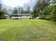 Spacious backyard featuring lush green grass, a storage shed, and mature trees, perfect for outdoor enjoyment at 625 Locust Rd, Locust Grove, GA 30248