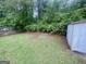 Fenced backyard featuring lush green grass, a storage shed, and mature trees, perfect for outdoor enjoyment at 625 Locust Rd, Locust Grove, GA 30248