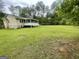 Expansive backyard featuring lush green grass, a screened in porch and mature trees, perfect for outdoor enjoyment at 625 Locust Rd, Locust Grove, GA 30248