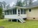 Charming screened-in porch with stairs, providing a relaxing outdoor space connected to the home at 625 Locust Rd, Locust Grove, GA 30248