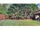 Backyard with grass and trees, enclosed by a brick wall and wooden fence at 11616 Spring Lake Way, Fayetteville, GA 30215