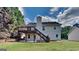 Home exterior featuring a deck, brick patio, and lush green lawn at 11616 Spring Lake Way, Fayetteville, GA 30215