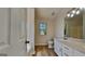 Bright bathroom featuring wood floors, a modern vanity, toilet, and sunlit window at 11616 Spring Lake Way, Fayetteville, GA 30215