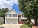 Charming two-story home with white siding, black shutters, two-car garage, and a well-manicured lawn at 11616 Spring Lake Way, Fayetteville, GA 30215