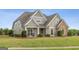 Beautiful home featuring stone accents, a manicured lawn, and a welcoming front porch at 2076 Towne Mill Ave, Canton, GA 30114