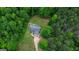 Aerial view of a charming home with a long driveway surrounded by lush trees and greenery at 3775 Highway 16 E, Sharpsburg, GA 30277