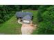 Aerial view of a charming home with a long driveway surrounded by lush trees and greenery at 3775 Highway 16 E, Sharpsburg, GA 30277