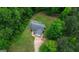 Aerial view of a charming home with a long driveway surrounded by lush trees and greenery at 3775 Highway 16 E, Sharpsburg, GA 30277