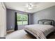 This bedroom has a large window, ceiling fan, neutral carpet and a gray painted walls at 3775 Highway 16 E, Sharpsburg, GA 30277