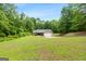Single-story home featuring a well-manicured lawn surrounded by mature trees creating a private and serene setting at 3775 Highway 16 E, Sharpsburg, GA 30277