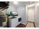 A well-lit laundry room includes modern appliances, a water heater, storage, and a patterned rug on the floor at 3775 Highway 16 E, Sharpsburg, GA 30277
