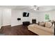A cozy living room features wood floors, a ceiling fan, a fireplace and a comfortable couch at 3775 Highway 16 E, Sharpsburg, GA 30277