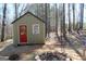 Outbuilding with red door and fire pit surrounded by trees at 460 Morgan Mill Rd, Brooks, GA 30205