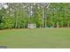 Backyard with a storage shed and blue outdoor seating in a wooded area at 175 Thomas Overby Dr, Sharpsburg, GA 30277