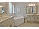 Bright bathroom with a modern soaking tub, double vanity, and wood-look tile flooring at 175 Thomas Overby Dr, Sharpsburg, GA 30277